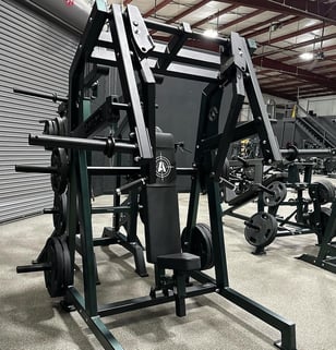 A chest press machine in a custom gym